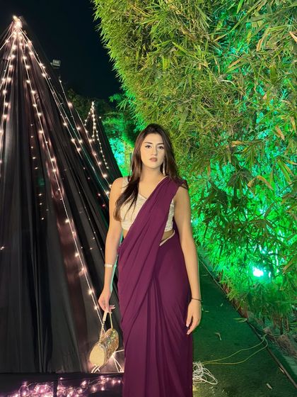 A full-length shot of the saree, standing in front of a beautifully lit tent. The look is perfect for an evening wedding function.