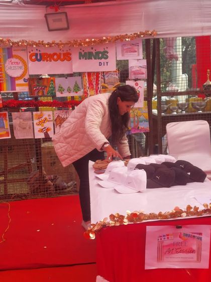 A glimpse of me setting up the cap painting station at a Christmas carnival. A lot of hard work goes into preparing for these events, but it's always worth it.