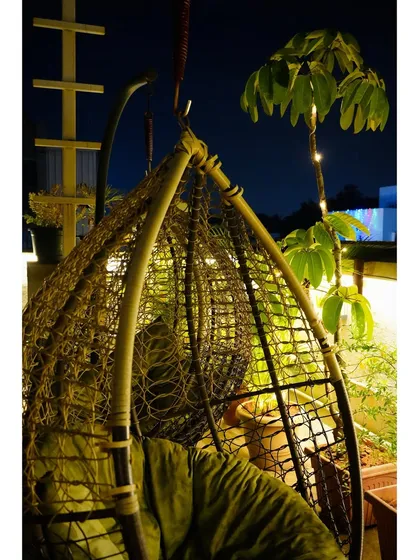 Our rooftop swing chair is a favorite spot for many. It's the perfect place to unwind at night, surrounded by fairy lights and plants, with a view of the city.