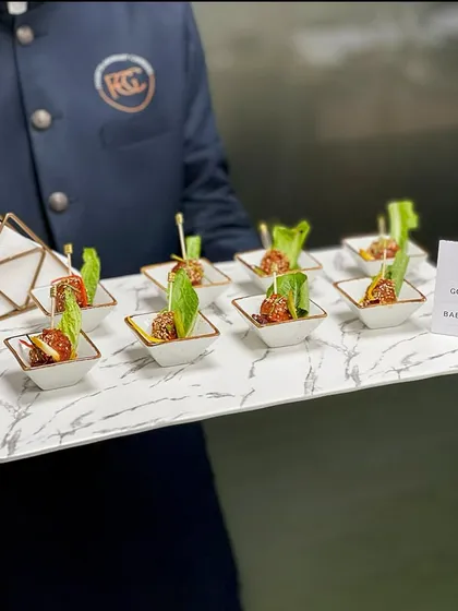 Our Gochujang Baby Potatoes being served on a marble-finish tray. This showcases our consistent quality and presentation for passed appetizers, ensuring every guest receives a perfect bite.