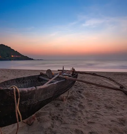 A traditional fishing boat rests on the sand at Gokarna after sunset. This long exposure captures the peaceful end of a day, with the twilight colors painting the sky.
