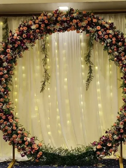 For a modern and elegant look, I created this circular floral arch using a mix of pink and white flowers. The backdrop of sheer white curtains with hanging fairy lights provides a beautiful, soft glow perfect for reception photos.
