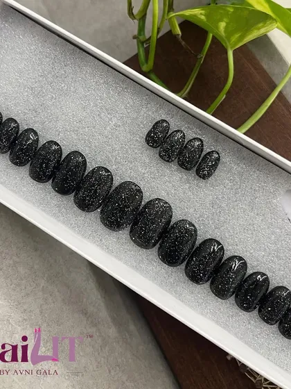 Sparkling black press-on nails. This set uses a textured, "sugar" glitter for a unique, sparkling finish that's perfect for a night out.