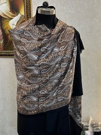 This pashmina features a classic all-over paisley pattern. It's a timeless design that adds a touch of sophistication to any outfit.