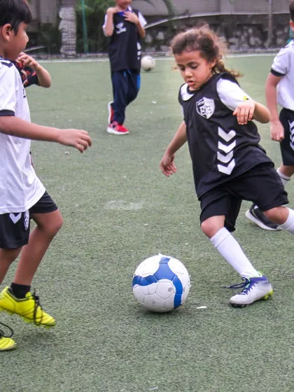 A young player skillfully navigates the ball during a practice game. We foster a dynamic environment where even our U8 players learn to think on their feet and play as a team.