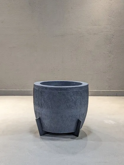 A full view of the grey textured planter with legs. Its modern design makes it a statement piece on its own.