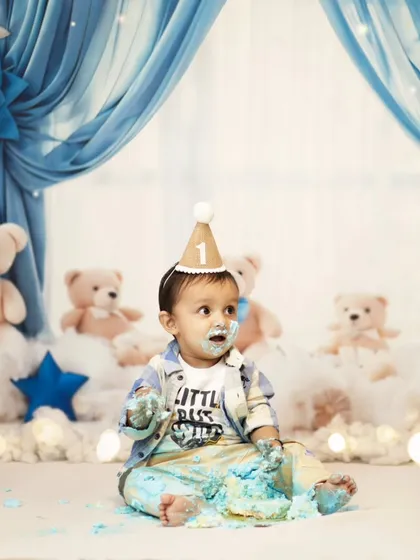 A moment of pause during the cake smash fun. Even with a messy face, he looks absolutely adorable in his little party hat.