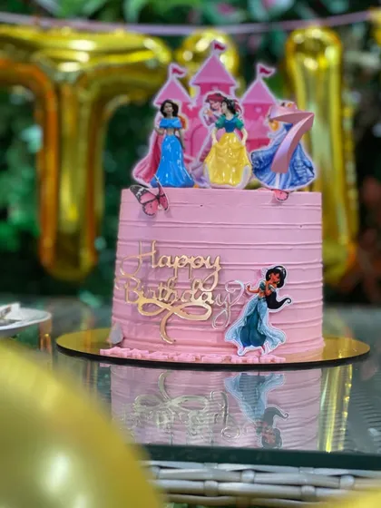A cake fit for royalty. This beautiful pink birthday cake features several Disney princesses, perfect for a magical princess-themed celebration.