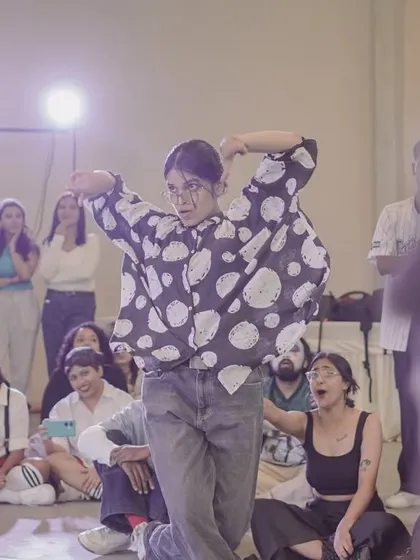 A dancer showing her style and confidence in the 2v2 battle circle, captivating the audience.