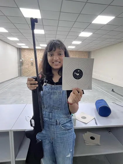 A student from our BS International School program proudly displays her target.