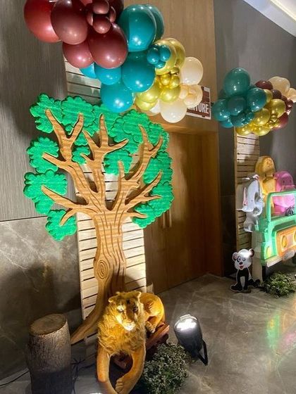 The entrance to the safari adventure, with a large tree prop and a tiger resting at its base, ready to welcome the party guests.