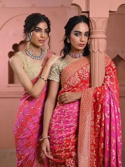 Two models showcasing the beauty of pink. On the left, a bandhani saree with a heavy border, and on the right, a rich red and pink brocade saree, both perfect for festive celebrations.