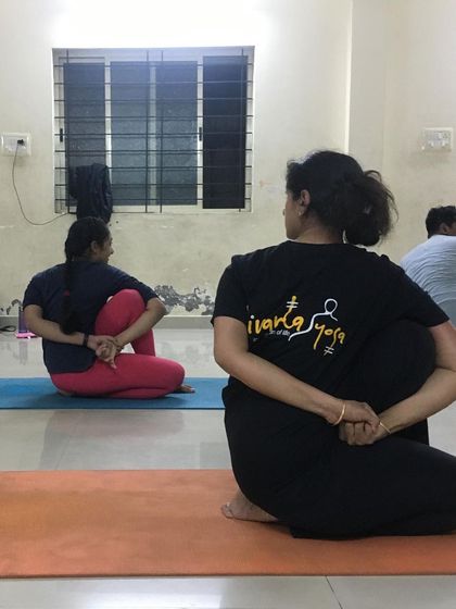 The back view of students in a seated twist shows the proper alignment of the spine and shoulders that we work towards.