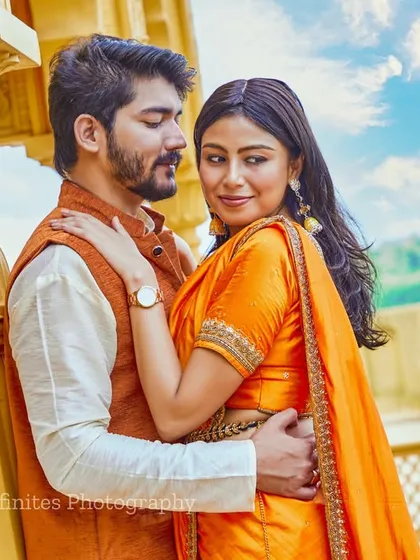 A close-up, romantic portrait captured at our golden palace set, highlighting the couple's connection and their vibrant traditional outfits.