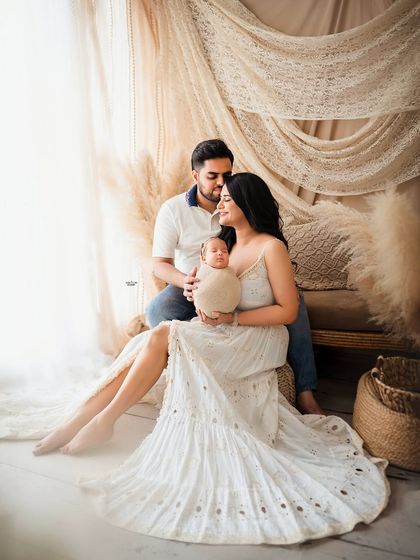 A full-length portrait showcasing the beautiful new family in a relaxed, boho-inspired setting.