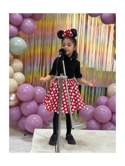 Dressed as Minnie Mouse, this little star performs her piece with charm and personality, bringing a beloved character to life.