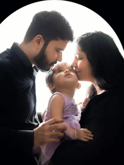 A dramatic and artistic silhouette portrait of a family, backlit to create a beautiful halo effect. A unique way to capture your family's bond.