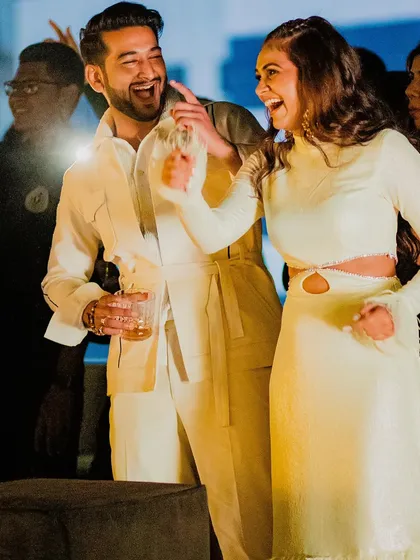 A happy couple at their party. The bride's modern hairstyle allows her to have fun without worrying about her hair.