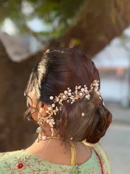 Subtle yet sophisticated, this beautiful bun is just what every wedding guest needs. The look is completed with a stunning pearl and gold hair accessory.
