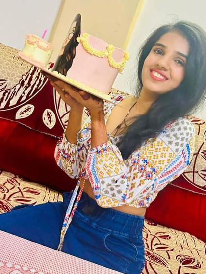 Holding her custom cake with a big smile. These are the moments we cherish.