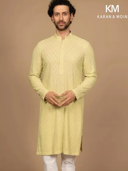 A full-length view of the pastel woven kurta, paired with simple white trousers. This showcases the effortless composition of the look, a study in poise, proportion, and the art of less.