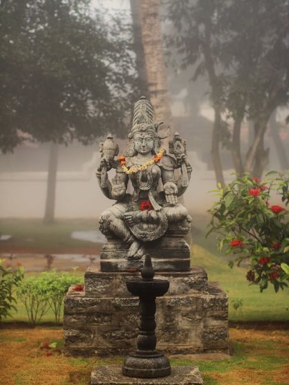 The idol of Goddess Bhuvaneshwari stands amidst our gardens on a foggy morning, creating a divine and serene presence. We believe her energy nurtures balance and healing.