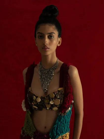 Taking the outfit off the chair and placing it against a solid red background. This isolates the piece and shows its full form.
