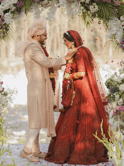 The groom gently places the garland on his bride during the jaimala ceremony.