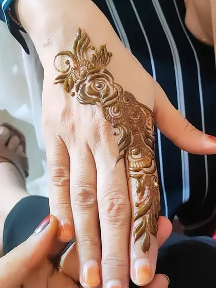 A graceful, flowing design for a single finger, combining floral and paisley elements.