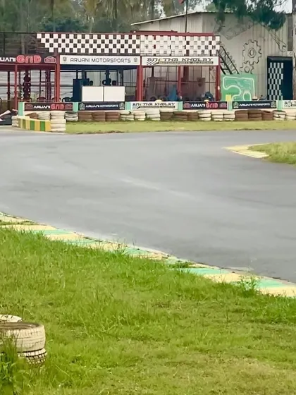 A clear view of a corner on the track leading towards the pit building, with its distinctive checkered flag design.