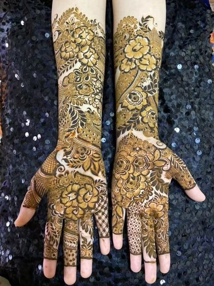 This full coverage bridal mehendi uses shading to create depth in the floral patterns. The design is dense but the details remain clear and beautiful.