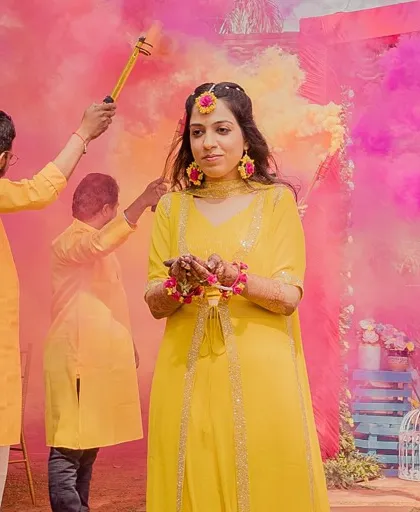 A beautiful bride making her Haldi entry surrounded by clouds of pink and yellow smoke. We love using color smoke to add a touch of drama and vibrancy to traditional ceremonies.