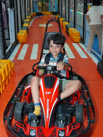 Future racer in training! A young driver gets ready for his lap on our indoor go-kart track. The track is designed for safety and fun, making it a highlight for any birthday party or day out.