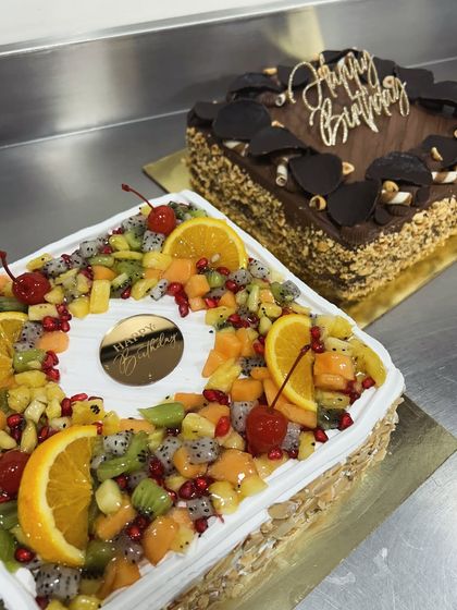 A fresh fruit cake and a rich chocolate hazelnut cake ready to go. We love making cakes that bring joy, especially when it's helping out a fellow baker in the community.