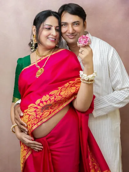 Celebrating motherhood in a way that feels true to you is so important. This expecting mother looks absolutely radiant in a traditional pink saree, showcasing her baby bump with grace and beauty during a studio maternity session.