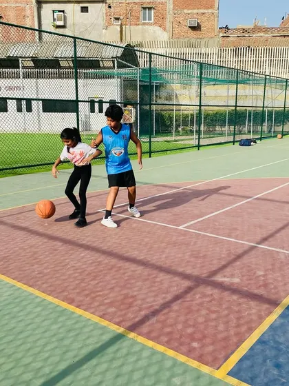 A coach works with a young player on her dribbling technique. One-on-one attention helps correct form early.