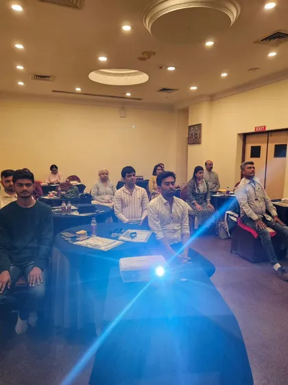 A moment of deep meditation during the Aura & Chakra workshop. The projector's light adds to the serene atmosphere.