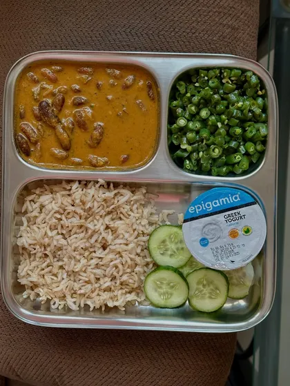 A plate with brown rice, rajma curry, sautéed beans, cucumber, and Greek yogurt. This is a staple in my kitchen for a quick, healthy, and protein-rich meal.
