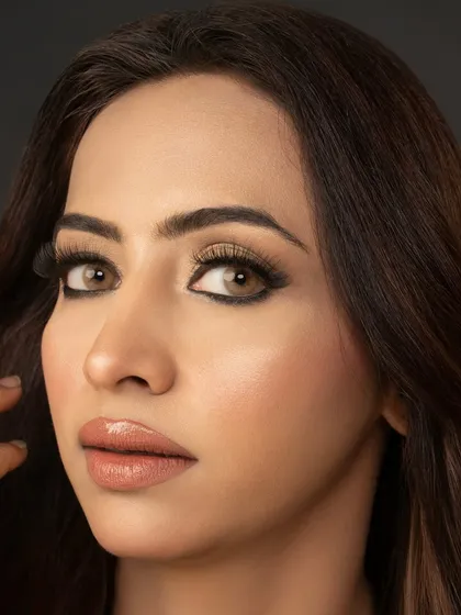 A classic beauty shot from a photoshoot. This look features a bold, graphic eyeliner, flawless skin, and a perfectly defined nude lip, showcasing a timeless glamour.