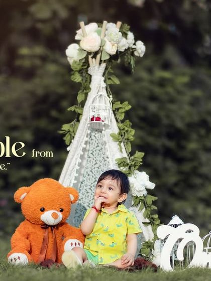 Adorable from every angle. An outdoor first birthday session with a lace teepee and a cuddly teddy bear, creating a perfect scene for a sweet portrait.