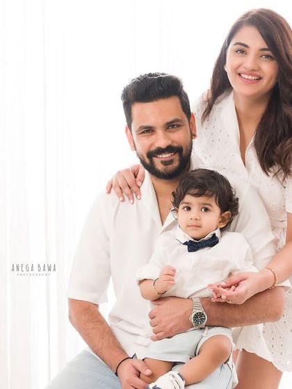 A classic portrait of a young family. The parents hold their son, creating a timeless image of love and togetherness.