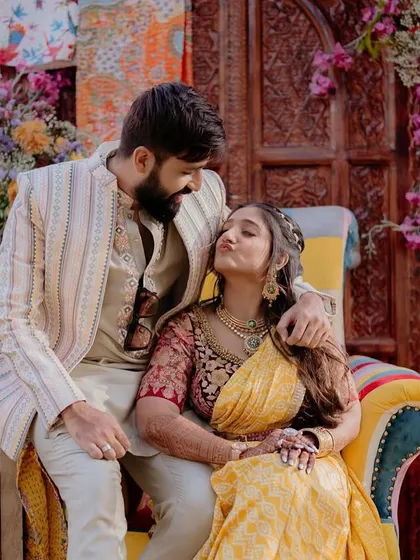 The bride and groom sharing a cute moment at the 'Rajasthani Folklore' Mehendi. The colorful, eclectic photo booth we designed was the perfect backdrop for their playful personalities.
