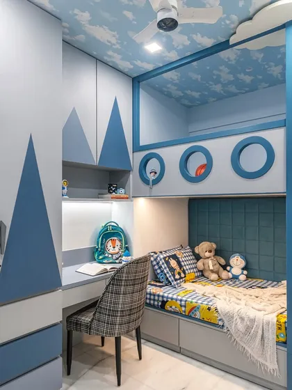 For this child's room, we built a custom bunk bed that combines playfulness with practicality. The design includes a cozy lower bunk, an upper play area with porthole windows, and an integrated study nook with its own lighting, ensuring the space can grow with the child from playtime to homework.
