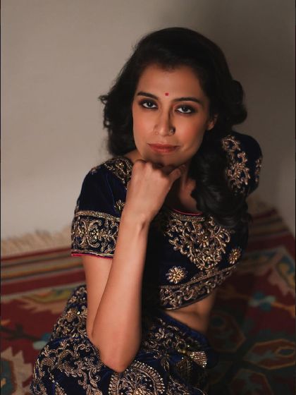 A classic, seated portrait in traditional Indian wear. Her direct gaze and calm posture create a timeless and elegant image.