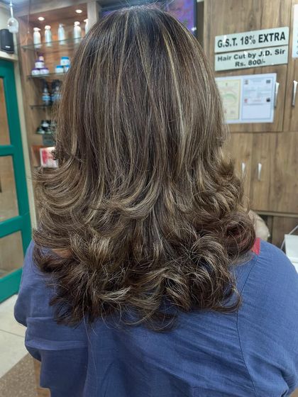 A classic layered cut enhanced with subtle caramel and blonde highlights. This technique adds dimension and movement to the hair, making it look fuller and more dynamic.