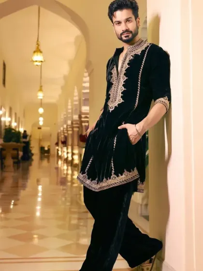 The full look of the black velvet kurta, showcasing its regal and elegant drape.