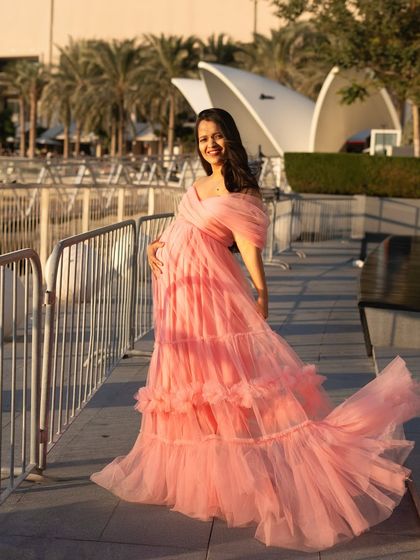 A joyful, radiant portrait taken during a walk along the Dubai waterfront. The flowing pink gown and the beautiful smile make this a perfect capture of pregnancy happiness.
