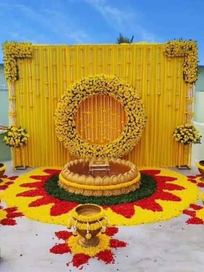 I can transform any space, even a rooftop, into a perfect venue for your Haldi. This setup includes a vibrant backdrop and a stunning floral rangoli.