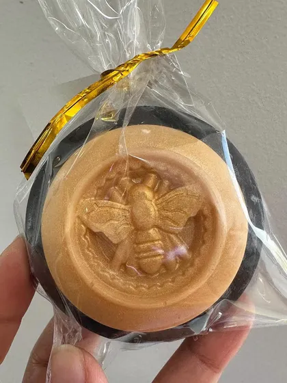 A custom-made moth gothic soap in black and gold, showing how I can match any theme for your celebration.