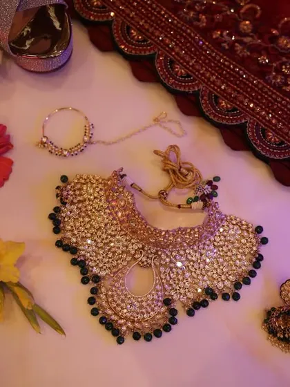A complete accessory shot for the bride, featuring her jewelry, shoes, and wedding dupatta, all beautifully arranged.